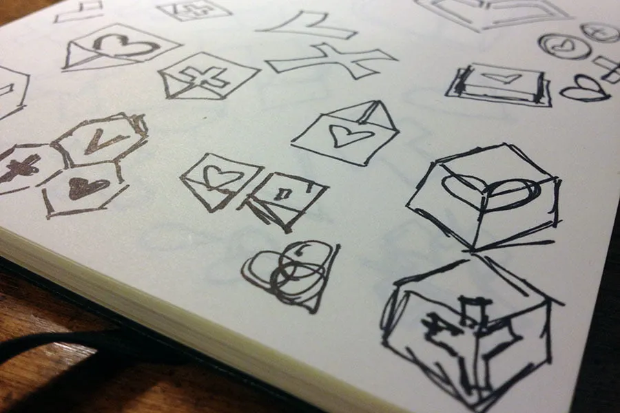 Sketches in a white notebook of the new logo icon for the business. 