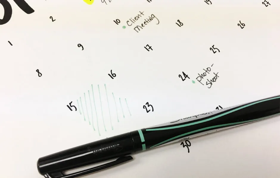 The January calendar printable with a thin-point sharpie laying on top. The calendar has writings on it. 