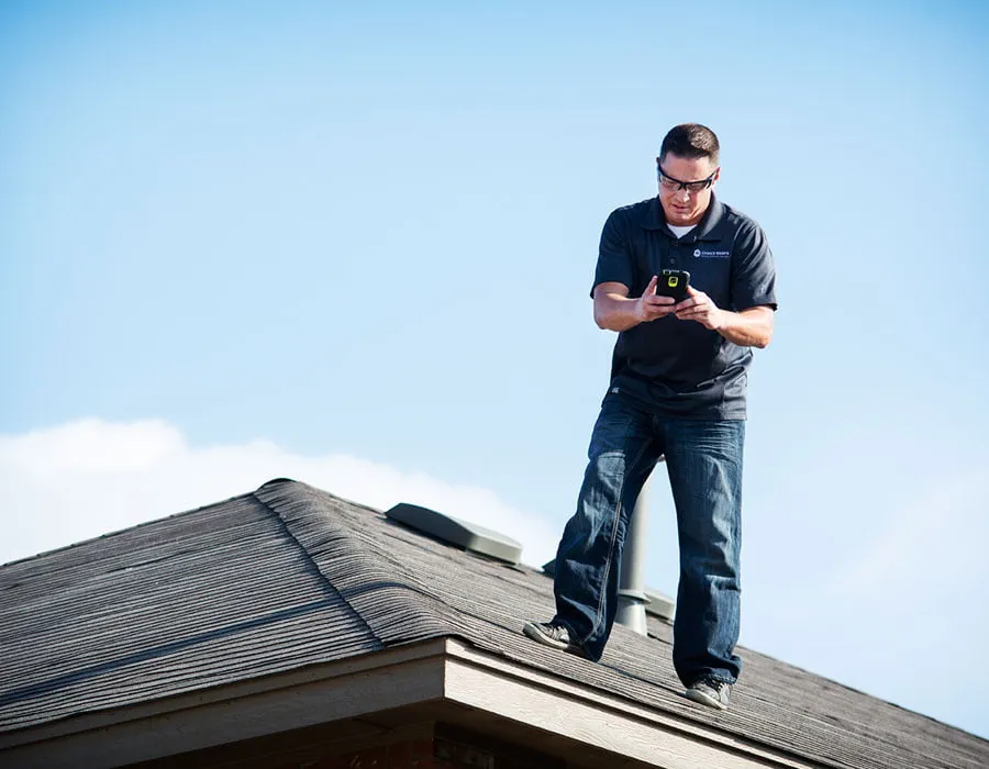 Choice Roofs Designs - myheartcreative Vance, the owner of Choice Roofs, takes measurements with a small device while standing on top of a home's roof.