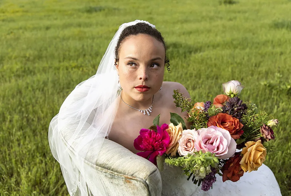 Looking Back on a Year of Web Design OKC - myheartcreative A bride holds up her bouquet while sitting in a velvet chair outside of a wedding venue.
