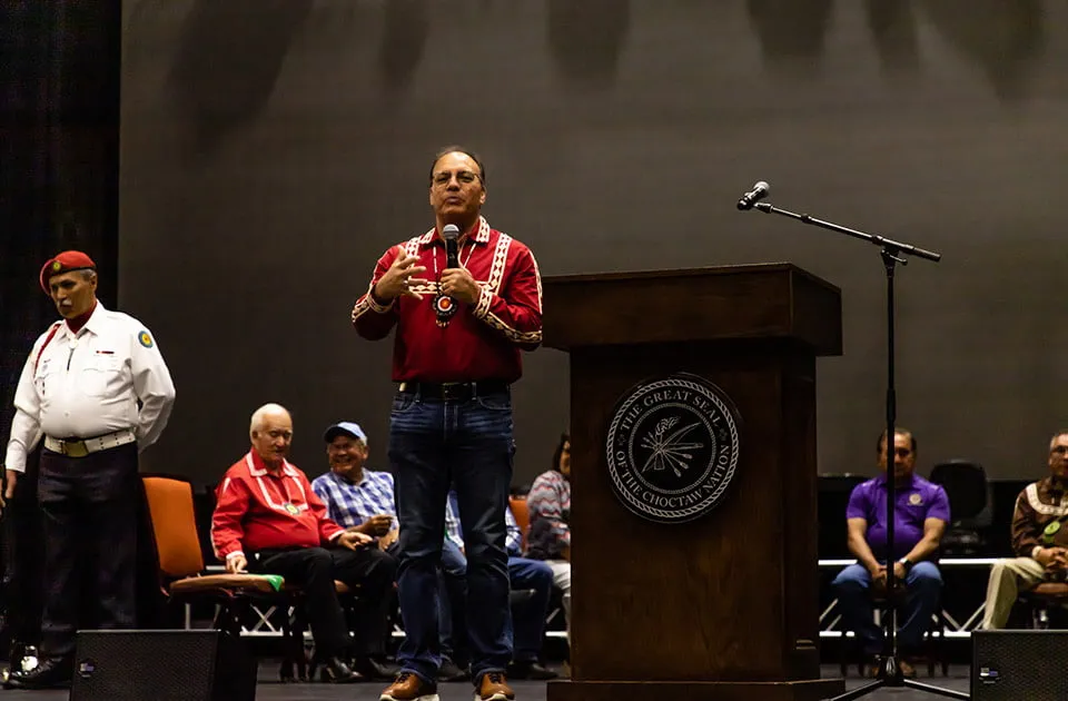 Chahtapreneurs - myheartcreative A speaker holds a microphone and stands at a podium to give a speech at the Choctaw Summit and Business Fair.