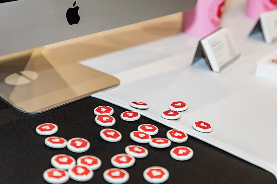 A pile of buttons with the myheartcreative logo icon sit on the booth table at the Choctaw Summit and Business Fair. 