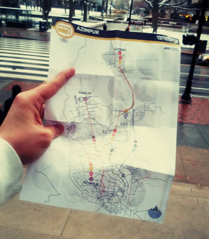 A man holds a printed map of the bus routes in Dhaka. 