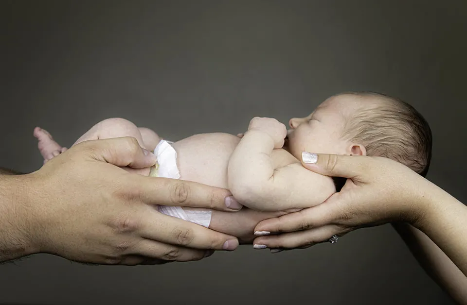 Looking Back on a Year of Web Design OKC - myheartcreative A mom and dad hold their newborn baby.