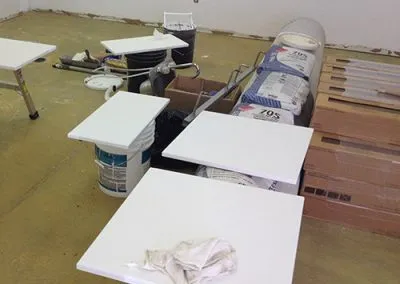 Kitchen cabinet doors are painted white and placed on industrial bags to dry.
