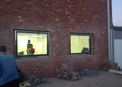 Piles of bricks lay outside the myheartcreative studio as new windows are put in. The Operations Director carries his young son on his shoulders inside the studio.