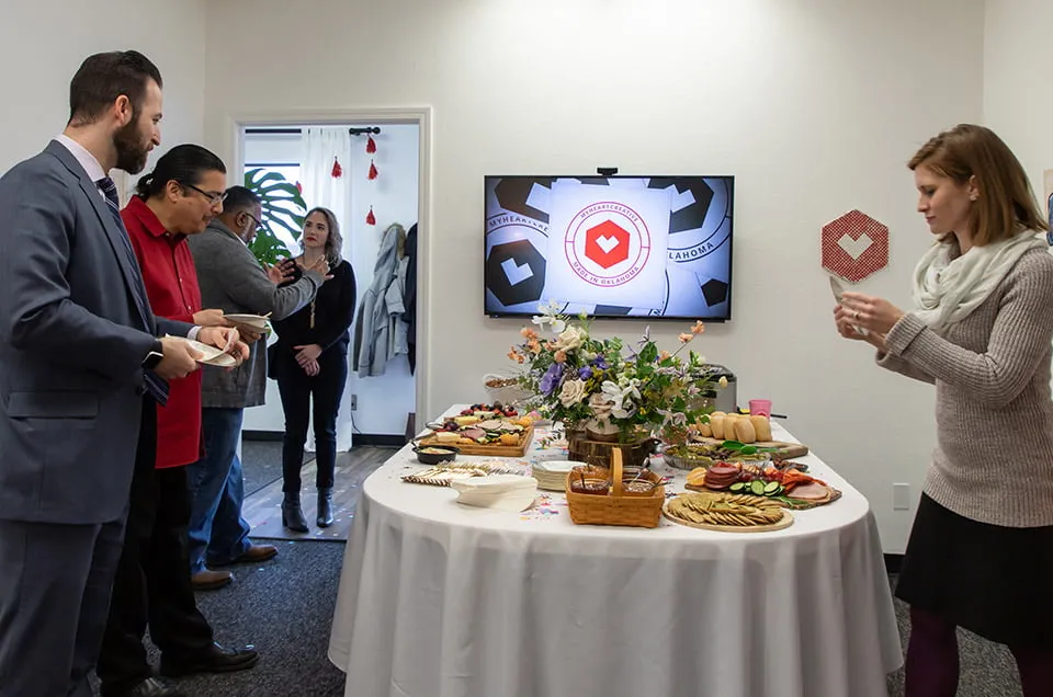 Our Clients Have Our Hearts - myheartcreative Several clients hold plates while grazing the food table at the Client Appreciation Party.