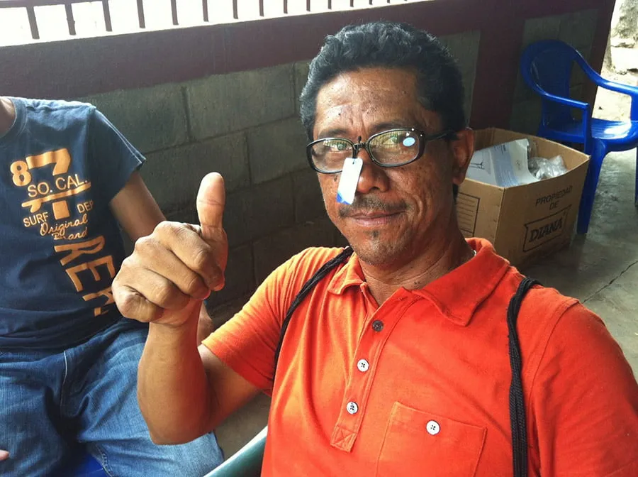 A man wears a new pair of glasses from Power of a Nickel and gives a thumbs up. 