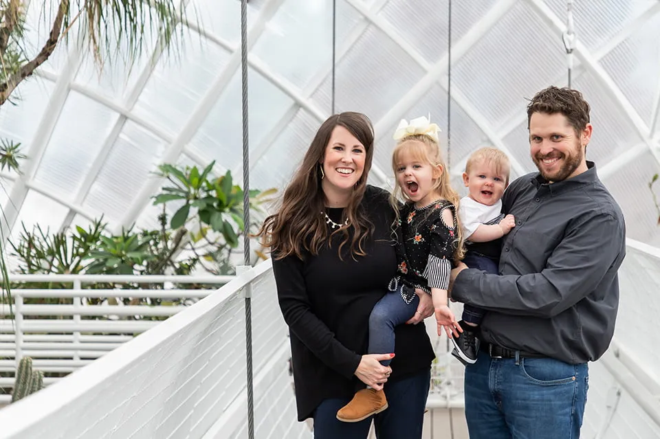 An Oklahoma photography shoot at the Myriad Botanical Gardens with the Taylor family. The husband and wife hold their two young children. 