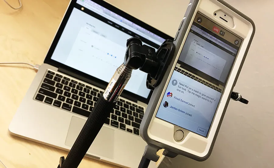 How to Blog - myheartcreative An iPhone is propped up on a tripod to record a live video about how to post a blog. The camera is aimed at a laptop.