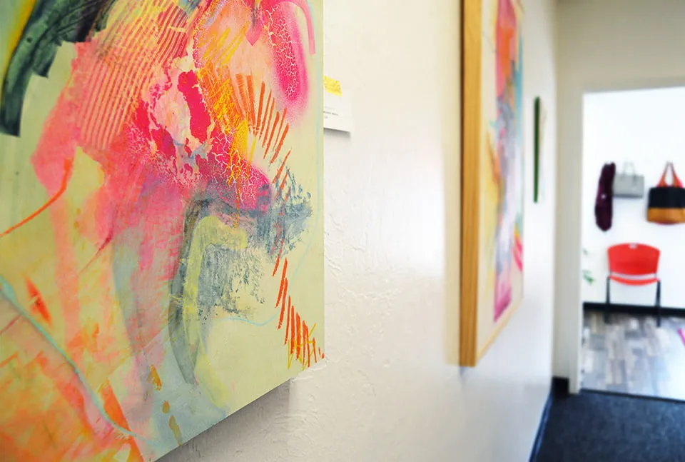 A multi-colored abstract painting by Virginia Sitzes hangs on the conference room wall at the studio. 