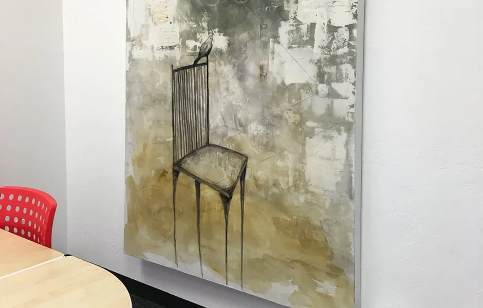 A large abstract painting by Brandi Downham. The painting shows a chair with a bird sitting on the tip edge of it. 
