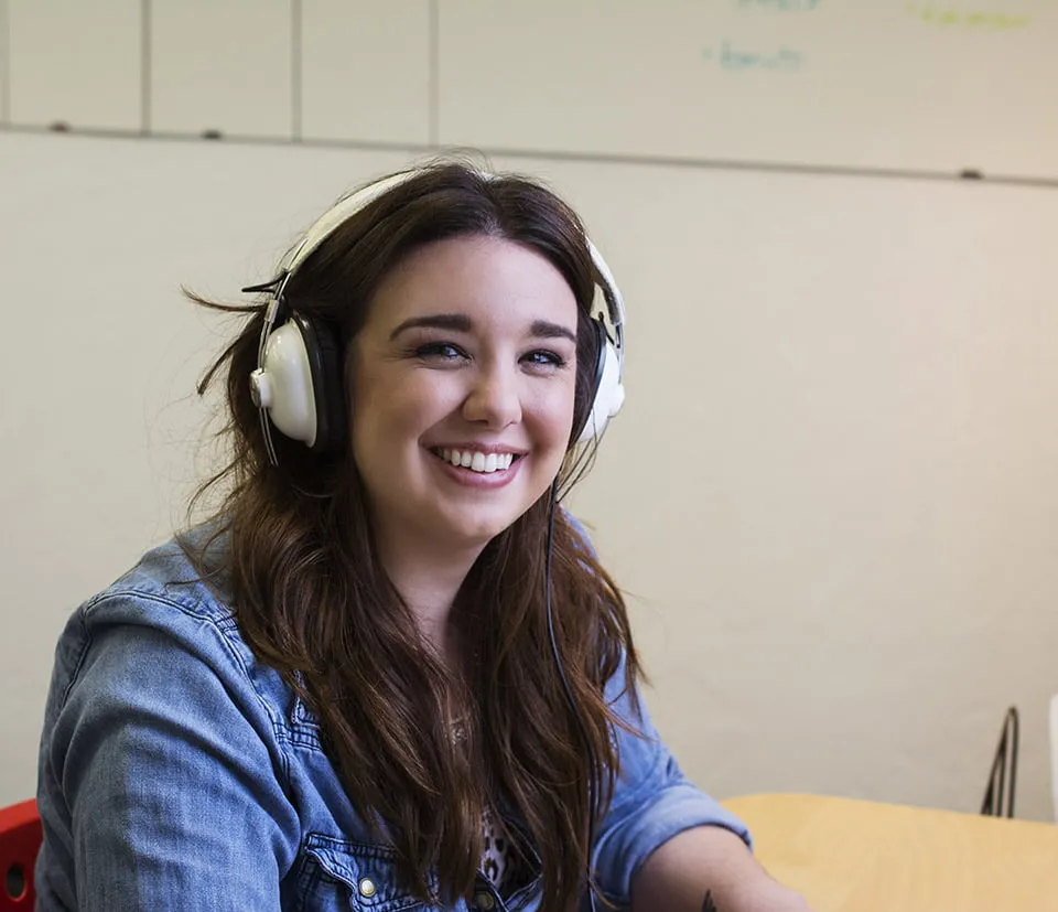 The Art of Graphic Design - myheartcreative A graphic designer working at her desk. She wears white headphones.