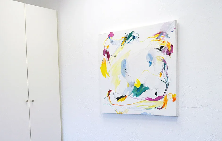 Space Altering Creator - myheartcreative A colorful abstract painting by artist Katelynn Noel Knick hangs on an office wall at the studio next to a white cabinet.