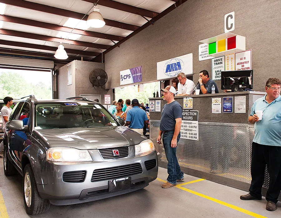 Louisiana's 1st Choice Auto Auction - myheartcreative A car is first in the auction lane, as a crowd surrounds the vehicle to view it. The auctioneer speaks in a microphone while sitting behind a raised desk.