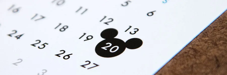 A logo icon in the shape of Mickey Mouse's head on a calendar design. 