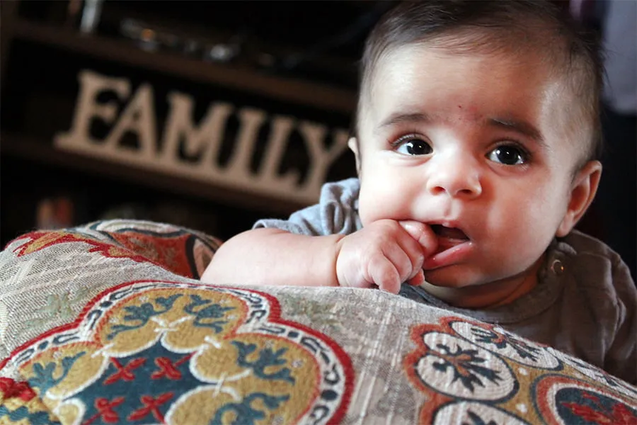 Baby Bubba's Tummy Shoot - myheartcreative Baby Bubba puts his hand in his mouth while he pays on a patterned pillow.