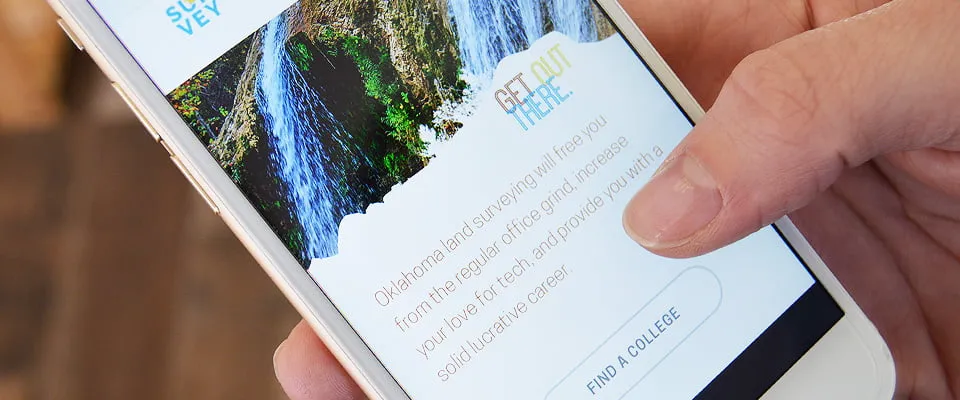 A hand scrolling on a mobile website design for Survey Oklahoma. 