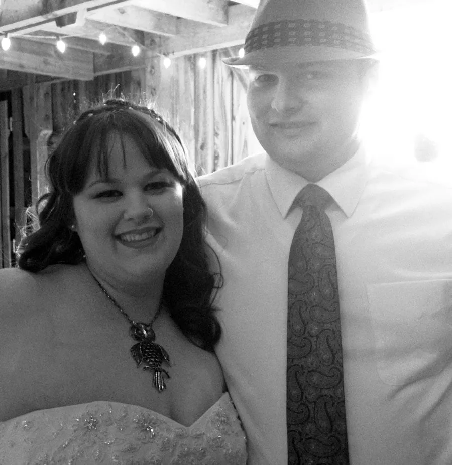 The bride and groom smile for a photo at their reception. 