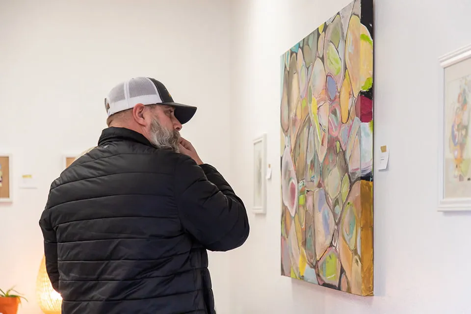 Our Clients Have Our Hearts - myheartcreative A client examines a painting on the wall of the conference room.
