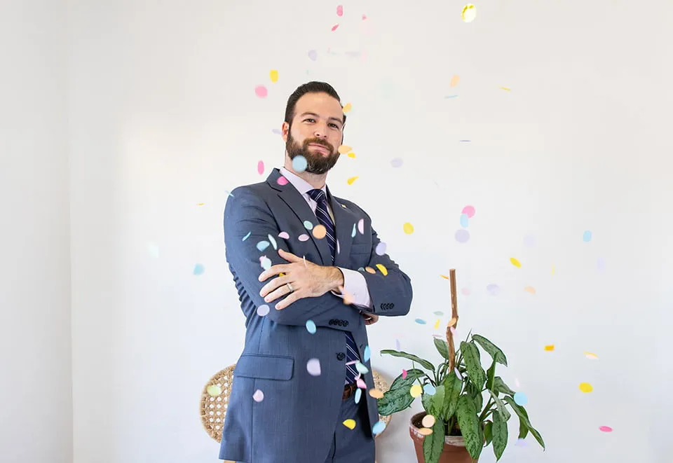 Our Clients Have Our Hearts - myheartcreative Phillip poses with crossed arms while confetti falls around him.