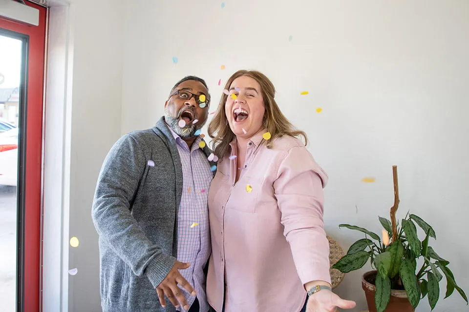 Our Clients Have Our Hearts - myheartcreative Sam and Amy smile wide and throw confetti.