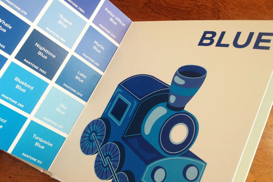 The inside of the baby Pantone Colors book. The page should a blue train, and on the left side, there is a collage of different shades of blue and their pantone chip numbers. 