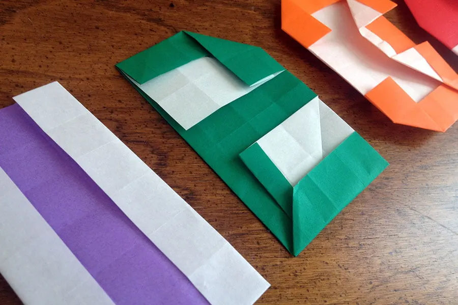 The origami paper cards partially unfolded on a table. 