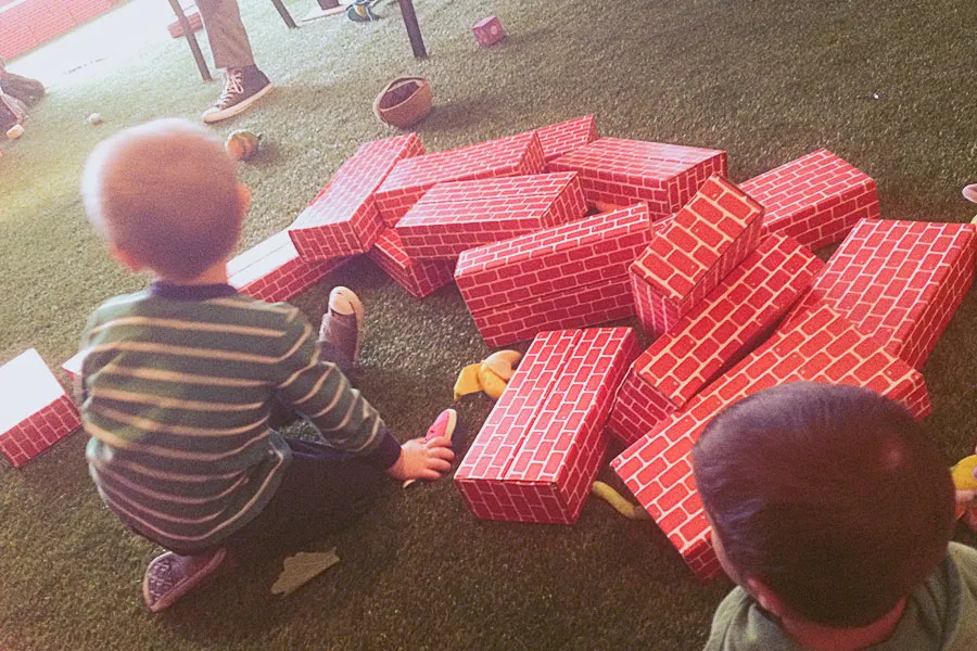 Maximus and a young boy play with foam bricks. 
