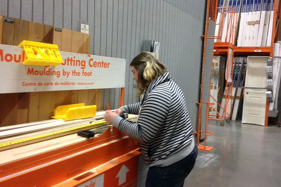 Amy measures wood boards at Home Depot. 