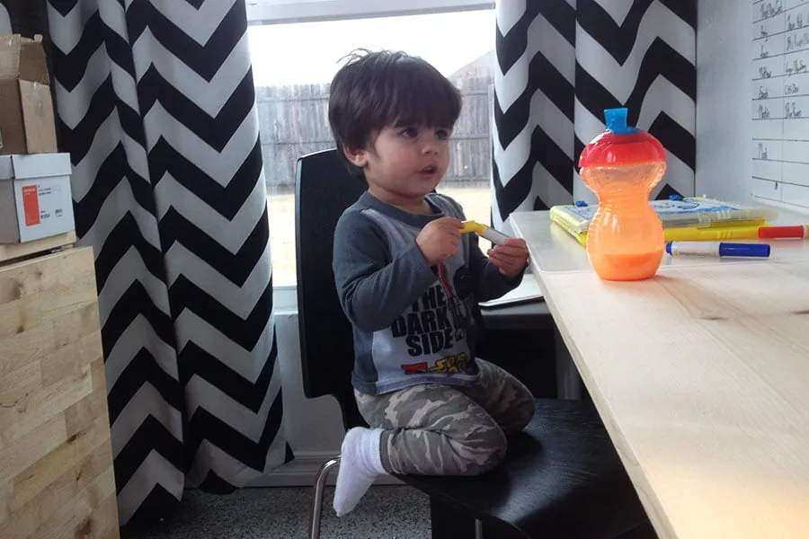 Maximus sits with a marker in his hand in the new studio. 