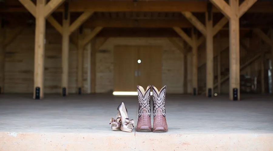 Styled Stationery - myheartcreative The groom's cowboy boots and the bride's peep-toe pink heels are photographed in the venue space.