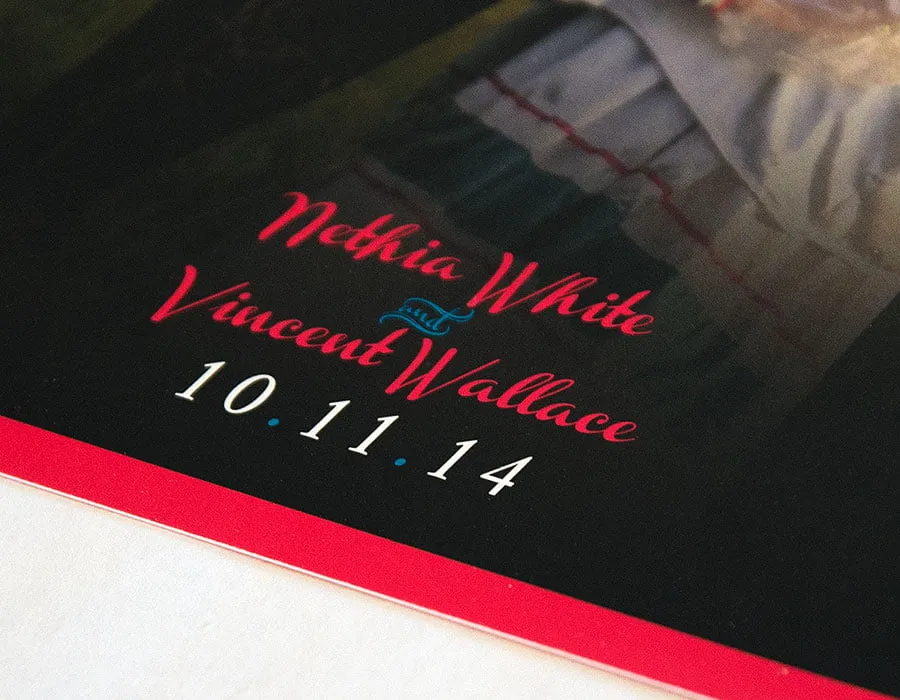 A close-up of the bottom center detail on the back of the wedding invitation design.  "Nethia White and Vincent Wallace 10.11.14"