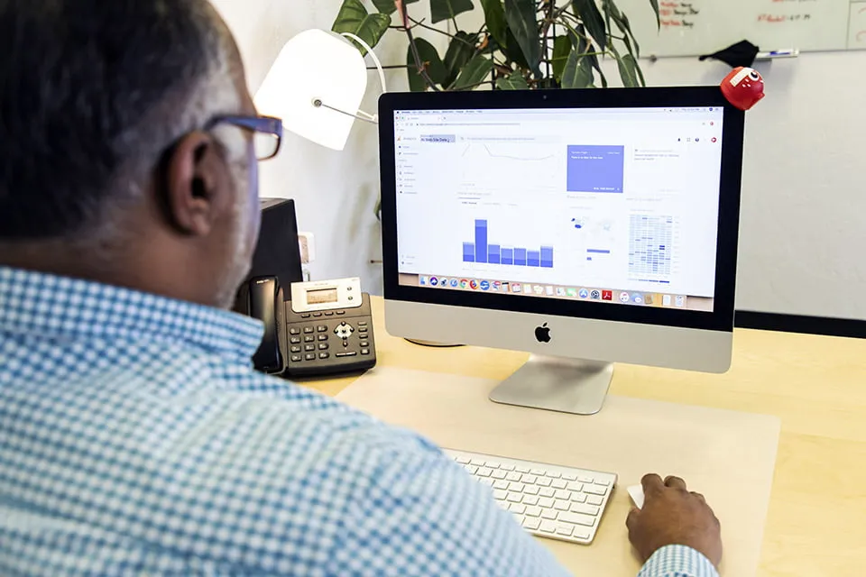 Sam reviews a client's Google Analytics dashboard on his Macbook as a part of myheartcreative's Oklahoma SEO services. 