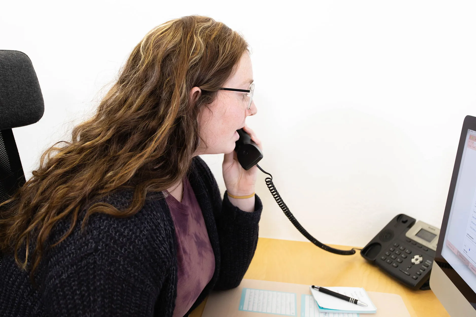 Morgan Cool takes a break from working on a client's online marketing OKC at her desk to answer the phone. 