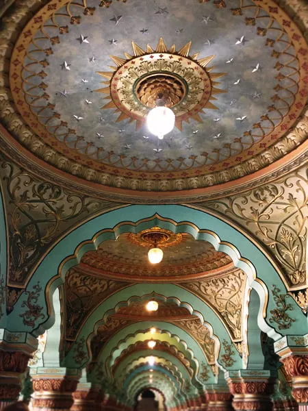 The ornate interior of a building in India. The ceilings are rounded with stunning architectural accents. 