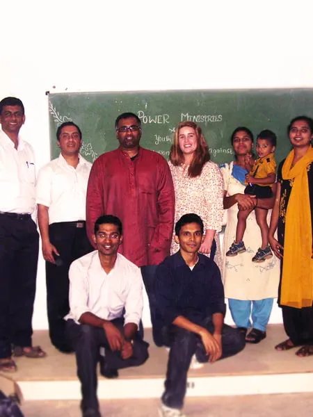 Sam and Amy smile with a group of people from Power Ministries. 