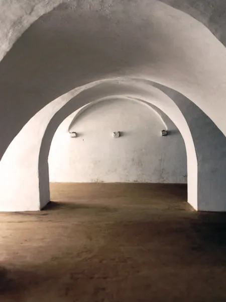 The arched entryways in a white building. 