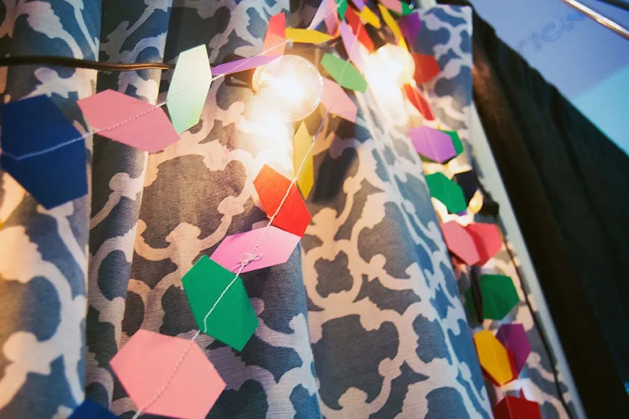 The homemade garland hangs with bulb lights as the backdrop to the booth. 