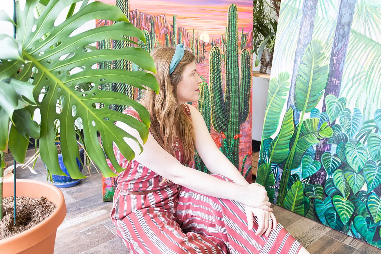 Artist Kyndall Rainey sits on the floor and observes her paintings at the myheartcreative studio. 