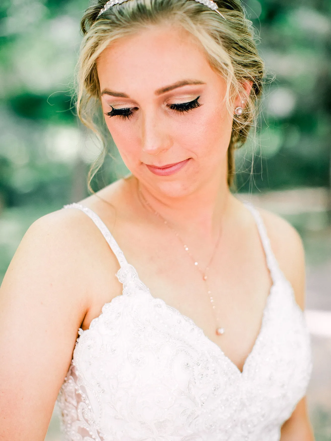 Derek and Shelby Thunderbird Chapel Wedding - myheartcreative A up-close shot of Shelby, the bride, as she gazes downward. Her makeup is professionally done and she wears a beautiful sleeveless wedding gown.