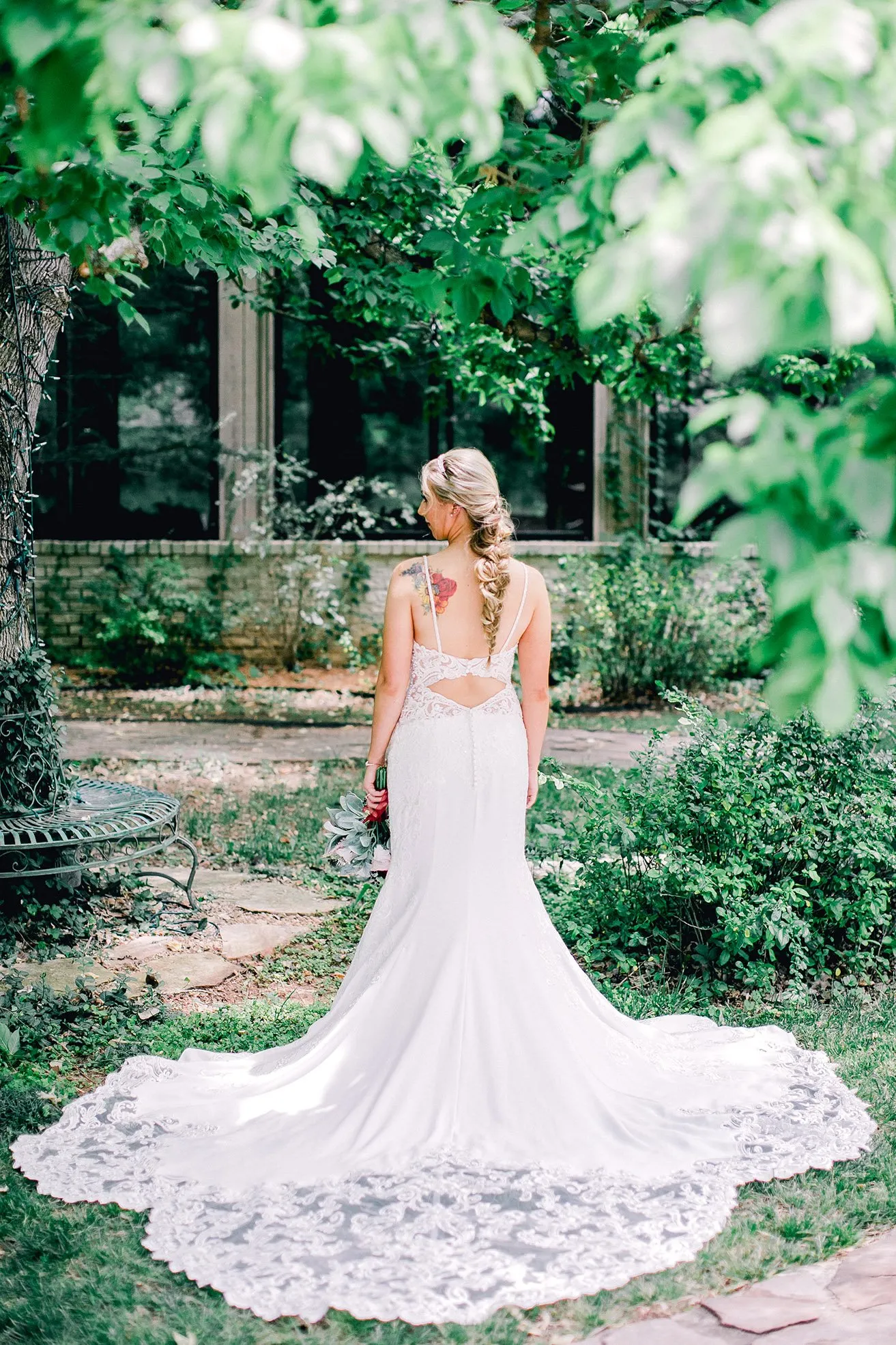 Derek and Shelby Thunderbird Chapel Wedding - myheartcreative An Oklahoma bridal photography shot of the back of Shelby's wedding gown. Her dress is complete with a beautiful lace overlay, with thin straps that show her floral tattoo on her right shoulder.