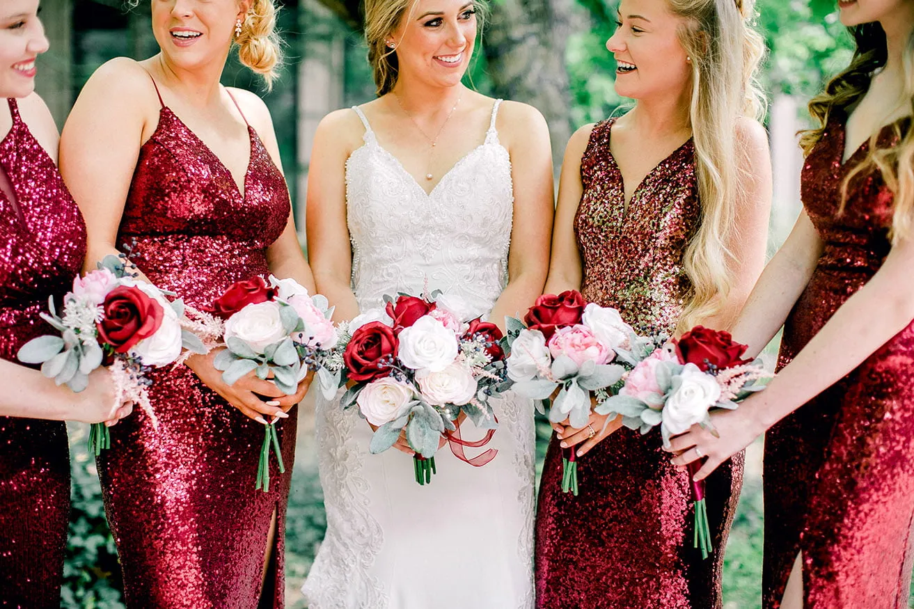 Derek and Shelby Thunderbird Chapel Wedding - myheartcreative Shelby, the bride, holds her bouquet and smiles at four bridesmaids wearing red sparkly dresses and also holding bouquets.