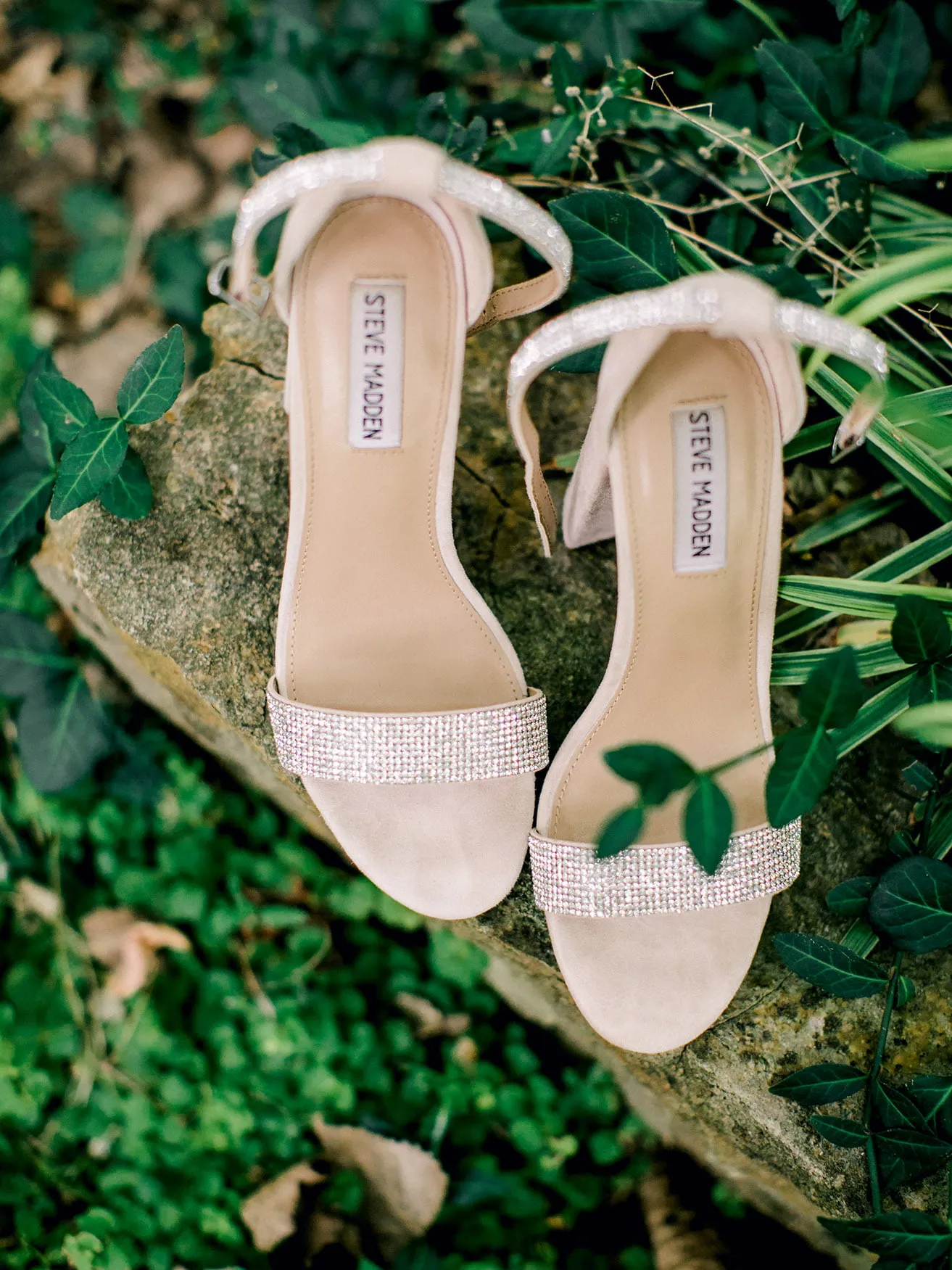 Derek and Shelby Thunderbird Chapel Wedding - myheartcreative The bride's sparkly Steve Madden heels sitting on a concrete fixture surrounded by greenery.