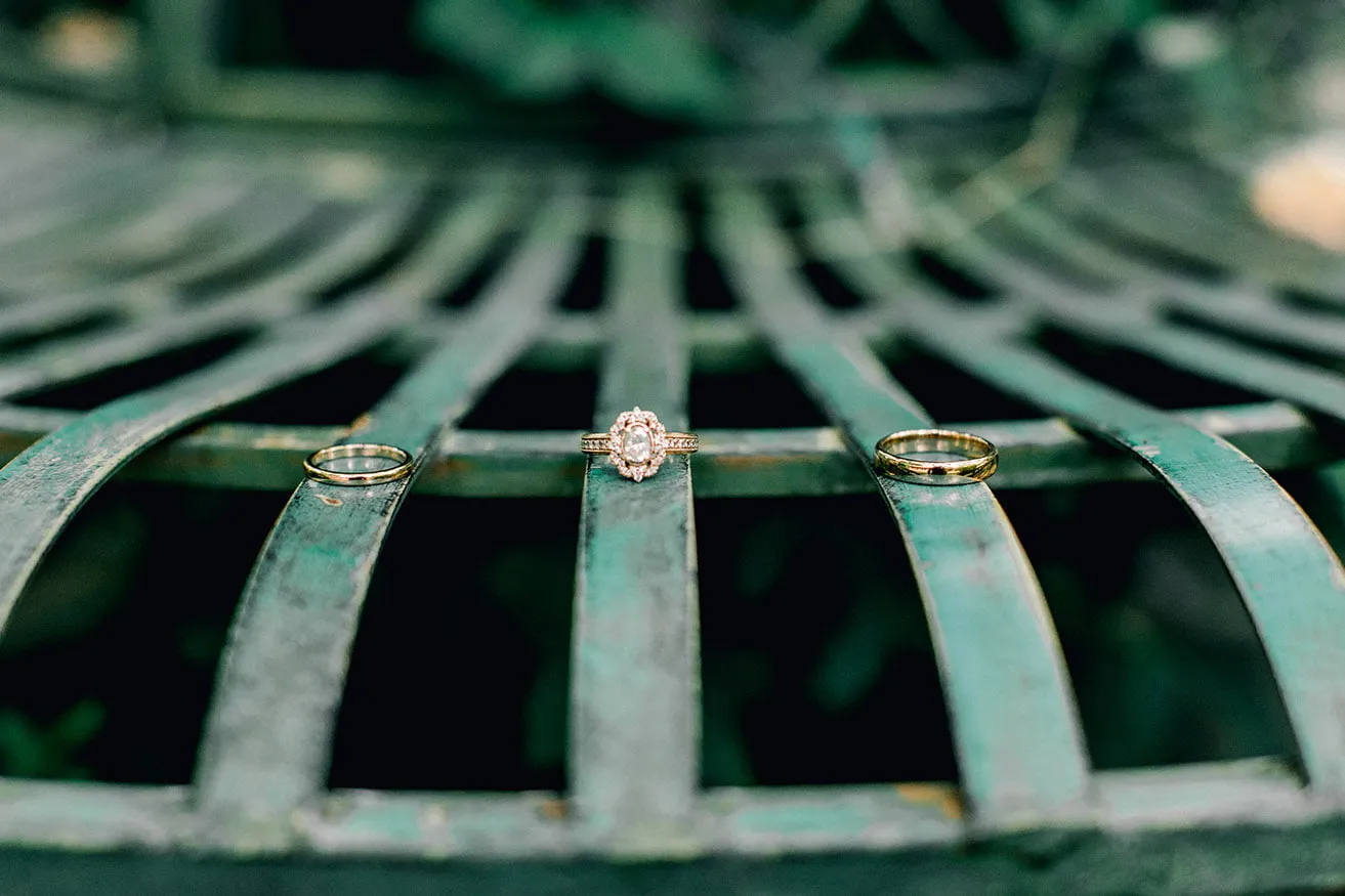 Derek and Shelby Thunderbird Chapel Wedding - myheartcreative An Oklahoma wedding photography detail shot of the bride's wedding rings and the groom's wedding band on a green metal chair.
