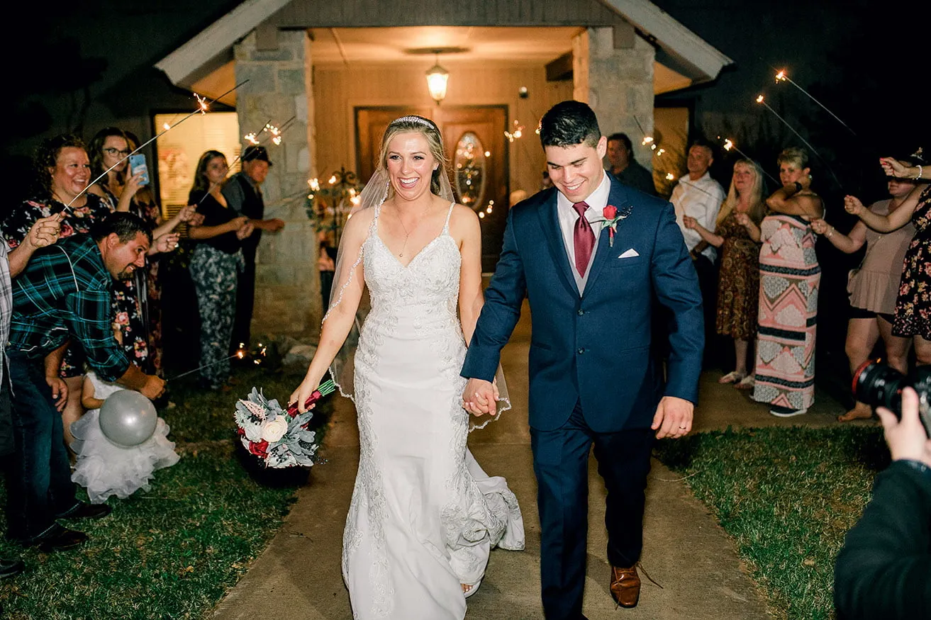 Derek and Shelby Thunderbird Chapel Wedding - myheartcreative Derek and Shelby hold hands while walking through a line of guests holding sparklers on each side. They are leaving their wedding.