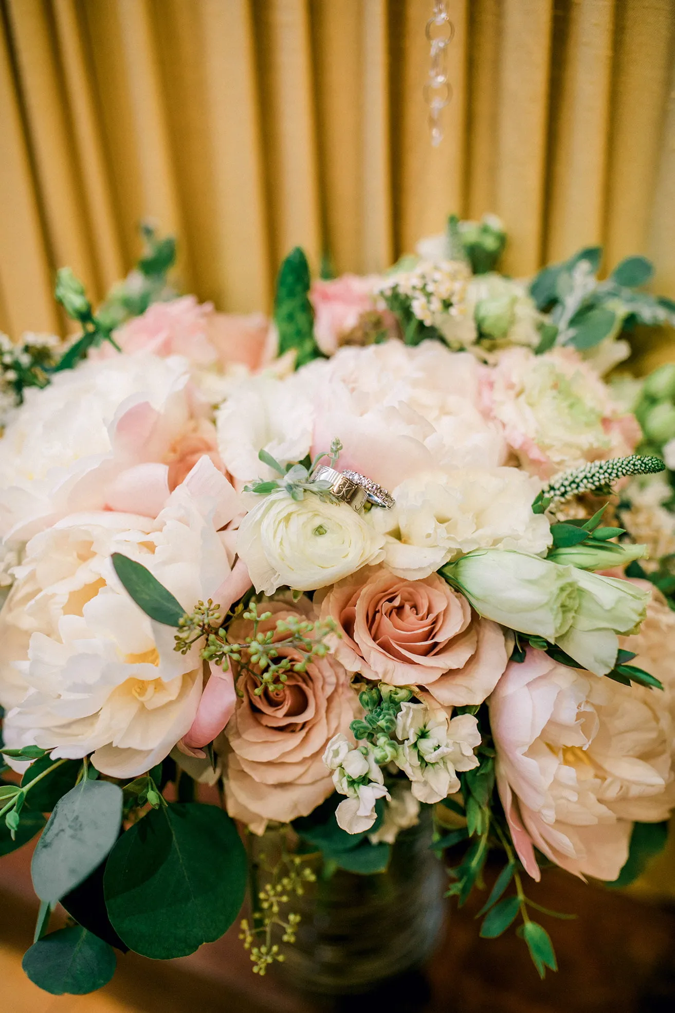 Jeff and Kasey The Palace Wedding - myheartcreative The couple's wedding rings are photographed together in the bride's bouquet of blush and white flowers.