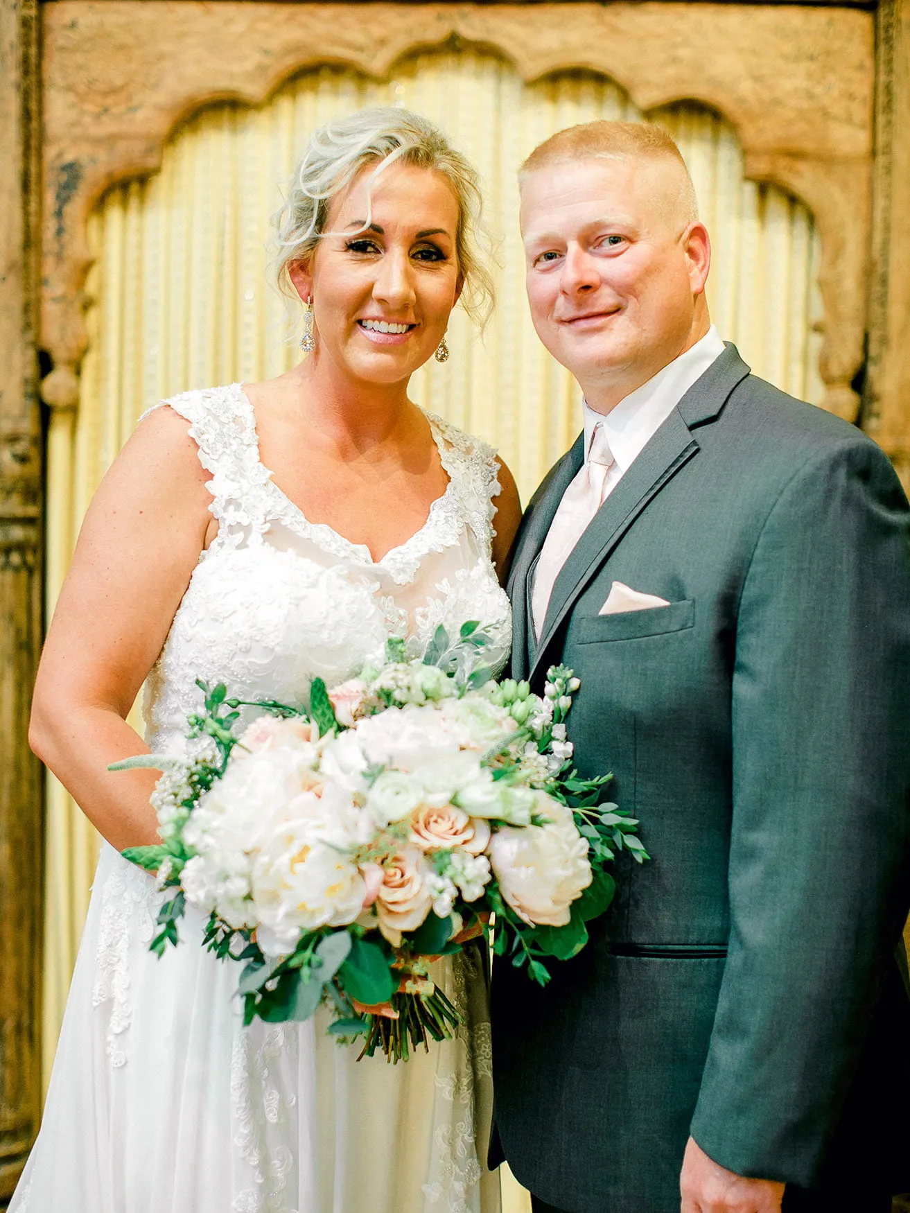 Jeff and Kasey The Palace Wedding - myheartcreative The bride and the groom pose for their first photo as a married couple. The bride is holding her bouquet.