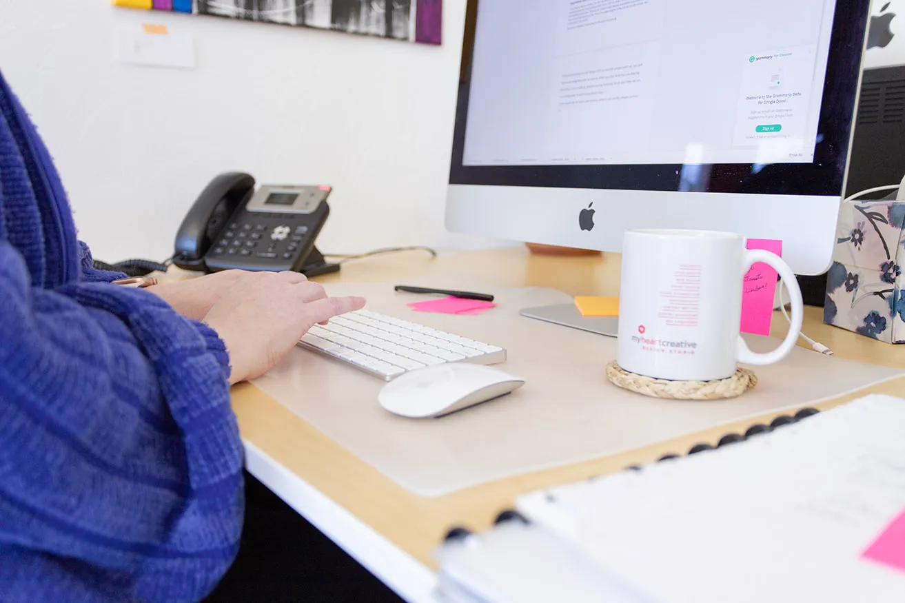 What Are the Best Digital Marketing Strategies for a Small Business? - myheartcreative April typing client content on her computer. She has a myheartcreative mug on her desk.
