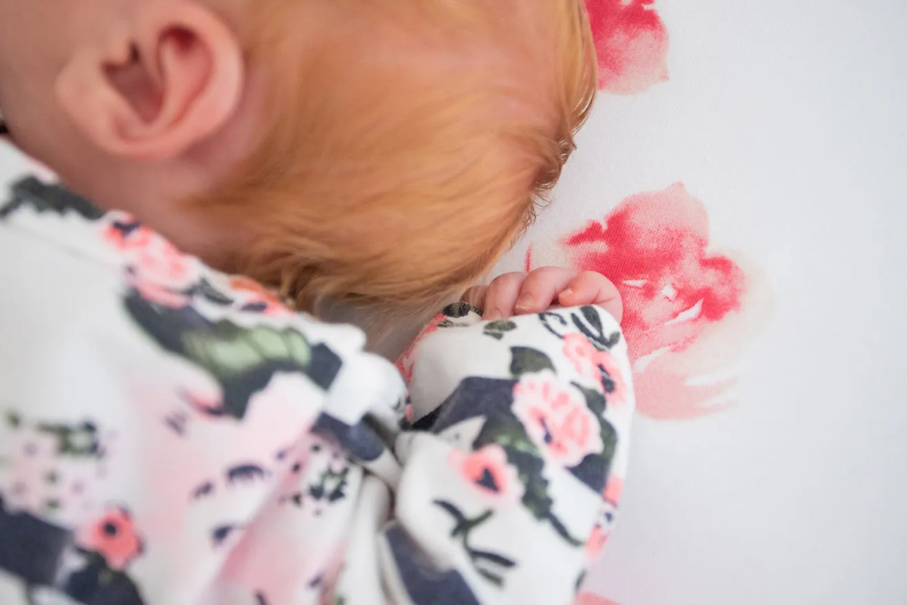 A close-up of a newborn baby's tiny hand during a photoshoot. 